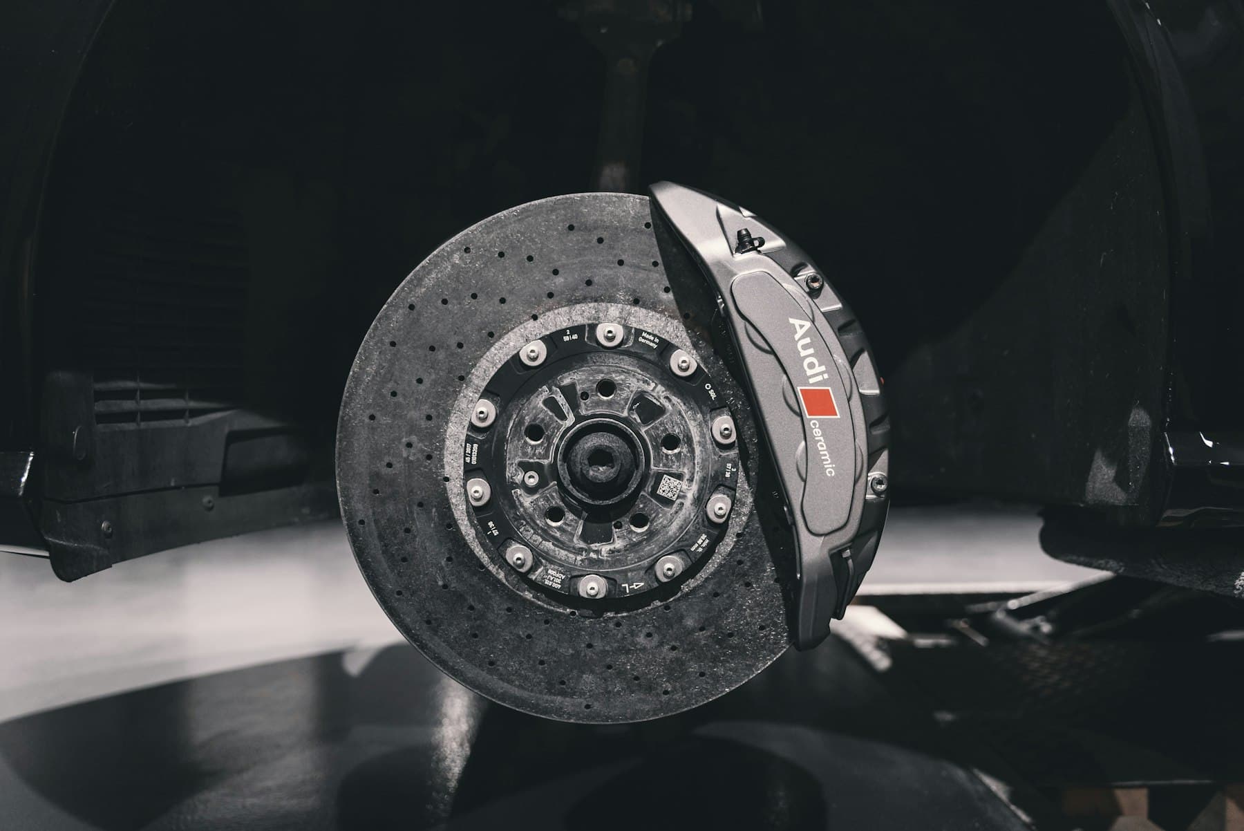 A brake disc and caliper assembly photographed against a dark background