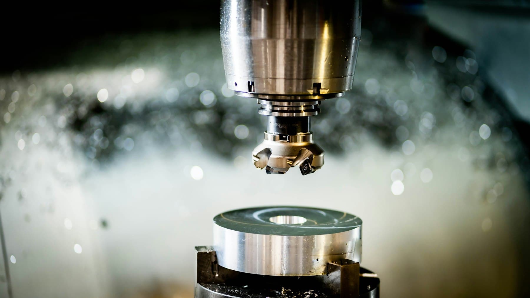 A milling cutter machining a metal surface under coolant