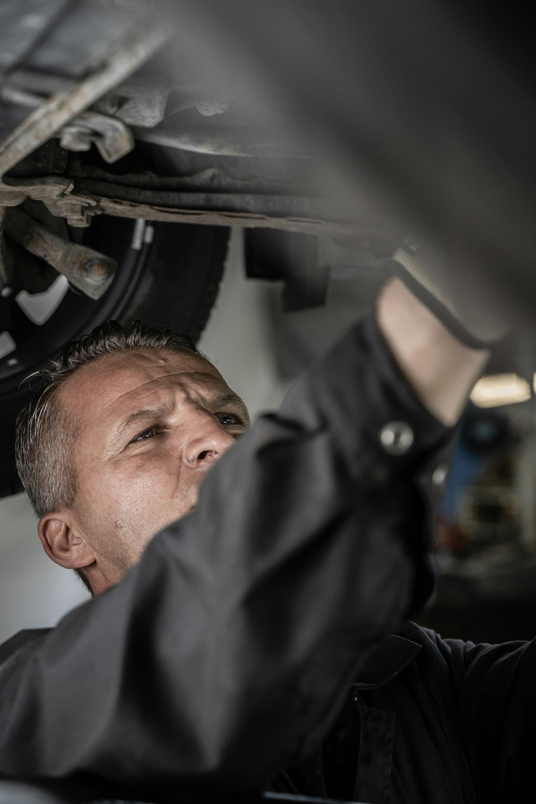 A mechanic working underneath a vehicle